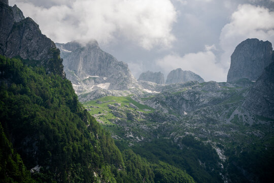 Majestic and atmospheric mountain landscape with soft clouds rolling over peaks.