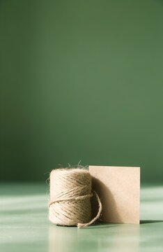 Jute twine and blank kraft card against a green background