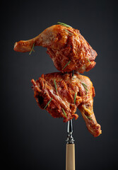 Naklejka na ściany i meble Hot chicken drumsticks on a fork.