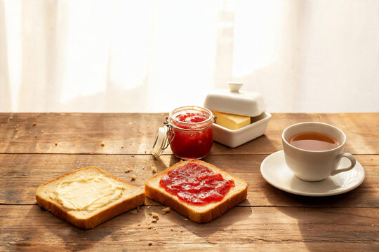 Toasted bread with butter and strawberry jam on rustic table