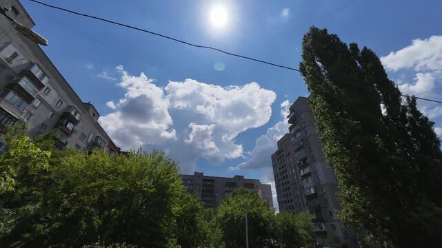 The sun's movement across the blue sky from 11 a.m. to noon on a clear summer day over the city time lapse