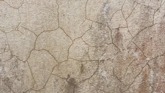Close up footage of a dry cracked cement wall with brown weathered texture for background