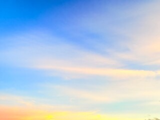 Naklejka premium Bright Blue Sky with Soft Golden Pastel Clouds at Sunset