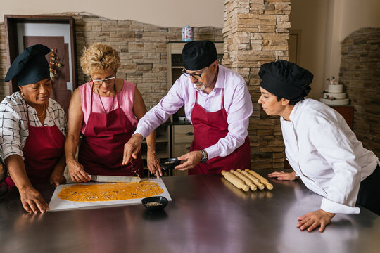 Chef spreading seeds on dough during cooking class