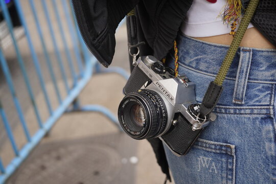 Una c&aacute;mara reflex retro de la marca PENTAX colgando sobre un pantal&oacute;n. Referencia a fotograf&iacute;a de pel&iacute;cula anal&oacute;gica y colecci&oacute;n. Madrid. Espa&ntilde;a. 1 de Octubre 2026