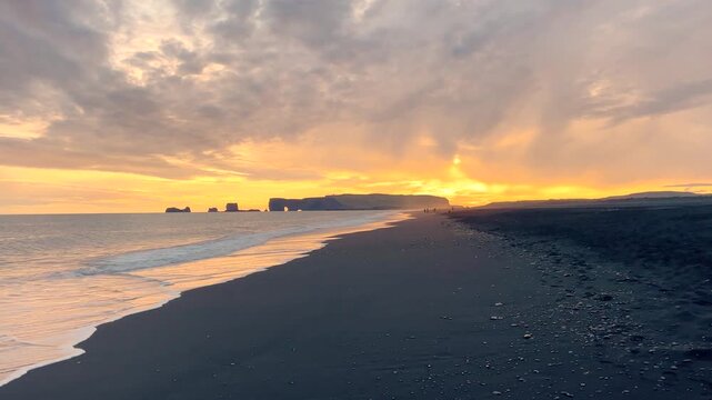 Dramatic Sunset Over Black Sand Beach and Ocean Waves in Iceland