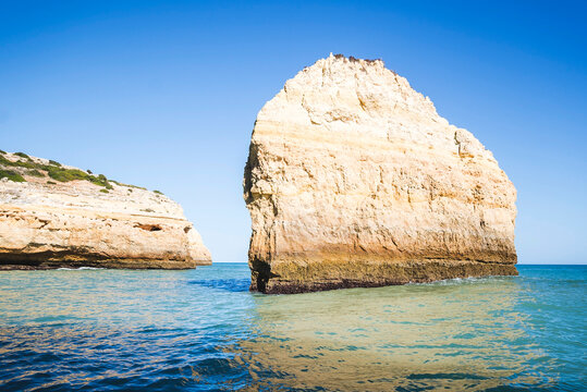 Large sea stack formation in the ocean along a coastal cliff, Marinha Beach, Benagil, Algarve, Portugal