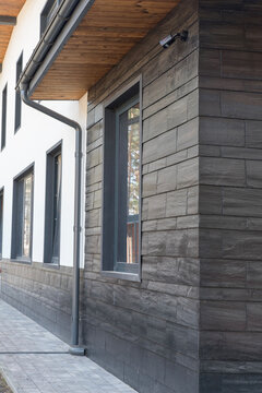 Dark slate stone cladding on house facade corner with window