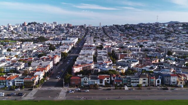 Aerial view of residential streets, Marina Green, and rows of houses in the Marina District of San Francisco, California, with distant hills under a partly cloudy sky.