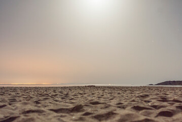 Sandy beach at night with distant city lights of Tangier, Morocco, with moonlit sky, seen from Bolonia dune, Costa de la Luz, Cadiz, Spain © Elsworth Frobisher