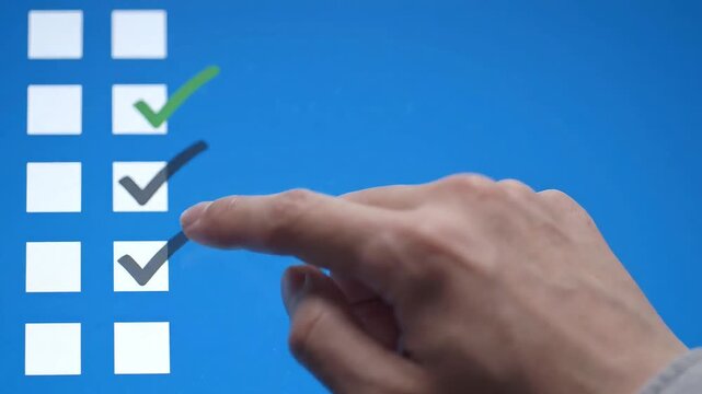 Hand tapping checklist items on blue touch screen display