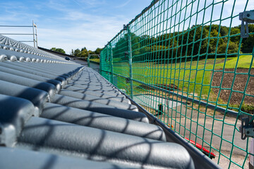 Roof construction with newly installed dark roof tiles and protective safety netting along the edge, overlooking a rural landscape in Germany © Feederline