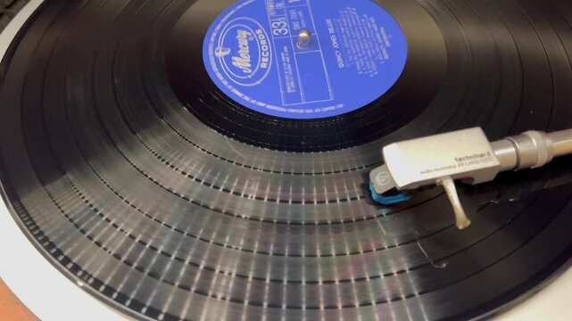 回転する黒いアナログレコード盤とターンテーブルのトーンアーム