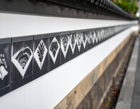 Black patterned tile border running along a white plaster wall in perspective, Japanese architecture with copy space