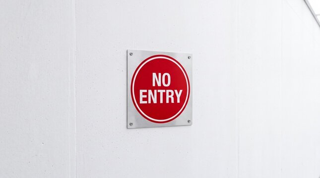 A circular red no entry sign attached to a wall warns people against trespassing into restricted areas to ensure safety and security in commercial buildings and industrial zones across the