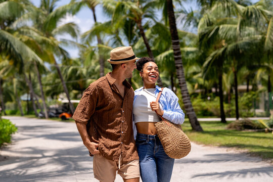 Diverse couple expressing pure joy and freedom in a sunny outdoor environment on summer vacation
