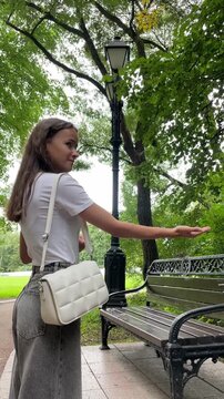 small great tit takes flight from a young woman's open palm beside a park bench, symbolizing freedom, human connection with wildlife, release, movement and outdoor wellbeing