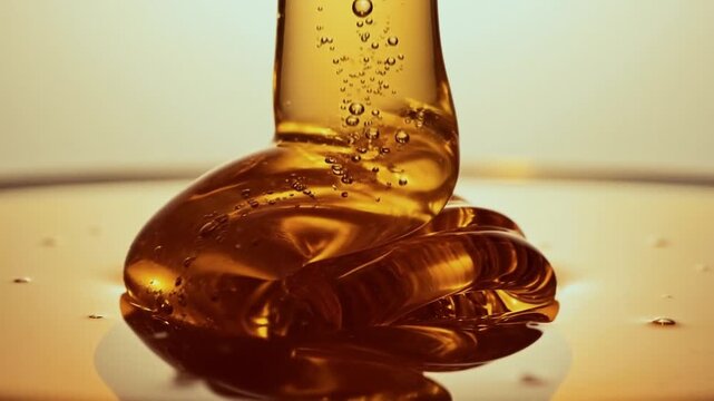 Honey drop falling into liquid with bubbles in close-up shot