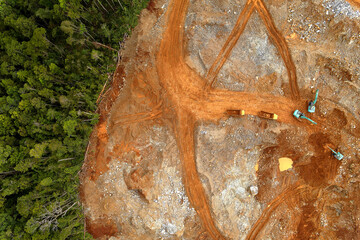 Aerial view of active cut and fill earthwork with excavators, dump trucks and haul roads on a large construction site. Heavy equipment, land grading, topography and industrial background. © KEN_SURVEYOR
