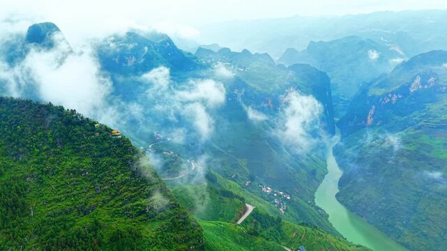 High aerial orbit over hillside villages and the Nho Que River appearing through clouds, Vietnam