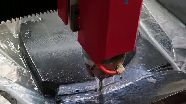 An industrial CNC machine uses  milling cutter to carve pattern onto  stone slab for funeral monuments