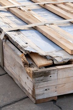 Wooden pallet with damaged parts and metal sheets in a storage area
