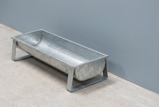 Empty livestock feed trough on a farm floor