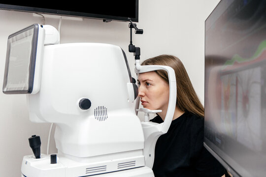 Female patient having an OCT eye scan with advanced ophthalmic diagnostic equipment during a vision examination in a modern eye clinic.