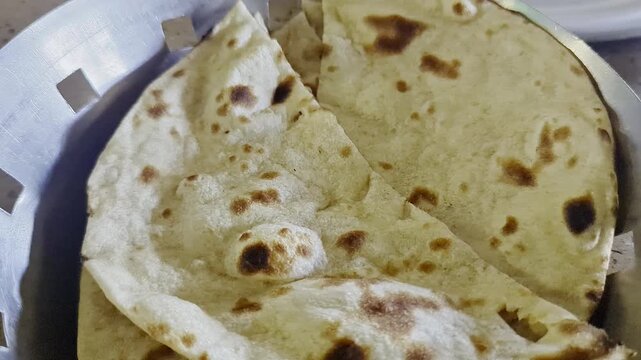 Closeup of freshly baked indian roti or flat bread served warm on a steel plate