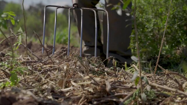 Rake preparing the ground and leveling soil in the field, slow motion