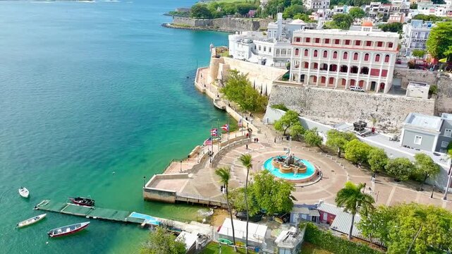 Drone video of part of Paseo la Princesa, the Fortaleza and the old city walls next to the bay of San Juan during the day. 