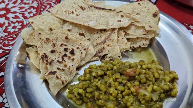Closeup of warm soft rotis or flat bread served with nutritious sprouted moong on plate