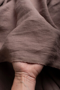 Hand Holding Chocolate Brown Linen Fabric Edge