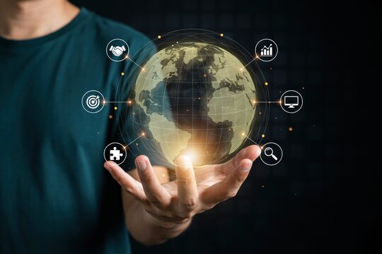 Digital globe with business icons held in hand representing global connectivity and technology