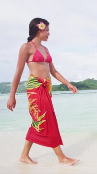 French Polynesia Vacation Travel woman walking on paradise motu beach on Bora Bora with Mount Otemanu wearing traditional pareo and Bikini in Tahiti. Raw vertical video of real woman without makeup