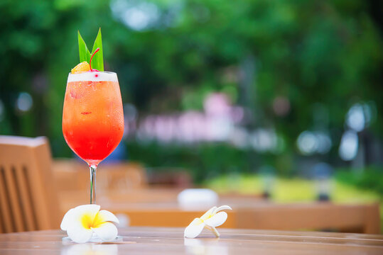 cocktail on the table. Cocktail recipe. favour cocktail include rum lime juice orgeat syrup and orange liqueur  sweet alcohol drink with flower in garden.