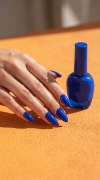 Hand with Blue Nails and Polish Bottle