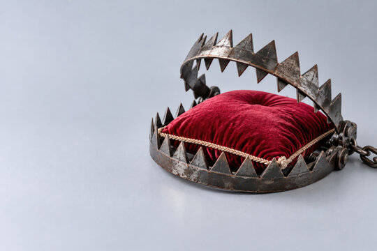 Red velvet cushion rests inside an open metal trap. Space for text.