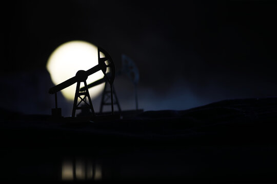 The crank balanced beam pumping unit under the curtain of night. Beam pumping unit under the night, closeup of photo