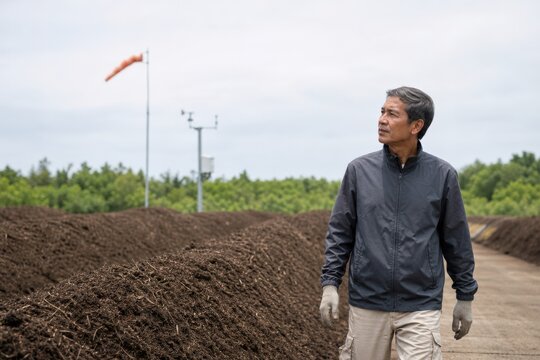 Compost Facility Odor Monitoring - Municipal consultant walking beside orderly Organics windrows