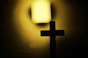 Fototapeta premium Silhouette of a Cross Against Bright Tunnel Light in Symbolic Spiritual Scene