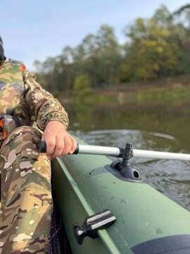Close-up of PVC Inflatable Boat with Oarlock, Aluminum Oar, and Camouflage Fisherman Concept
