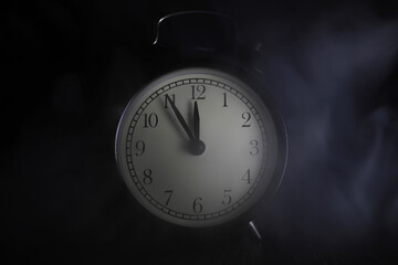 Fototapeta premium Vintage Analog Alarm Clock in Dim Light with Smoke, Emphasizing Time and Mystery