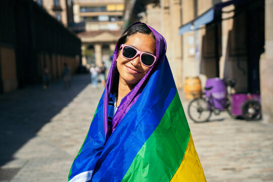 Woman smiling, celebrating lgbtq pride with rainbow flag