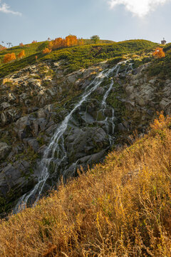 Waterfall Bear in Krasnaya Polyana, Sochi, mountain stream in autumn, rocky landscape
