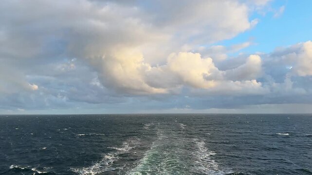 Dark wavy sea surface with wake behind by moving vessel