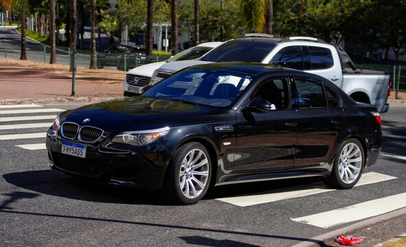 Black BMW M5 E60 Sports Sedan Front Three-Quarter View On Sunny Urban Street Crosswalk