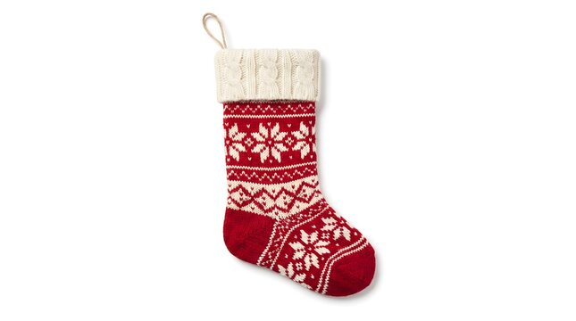 A festive red and white knitted christmas socks decoration featuring a traditional christmas candy stick isolated on white