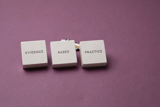 Three white blocks spelling evidence based practice arranged on a purple background.