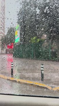 Rainy urban street viewed through wet window